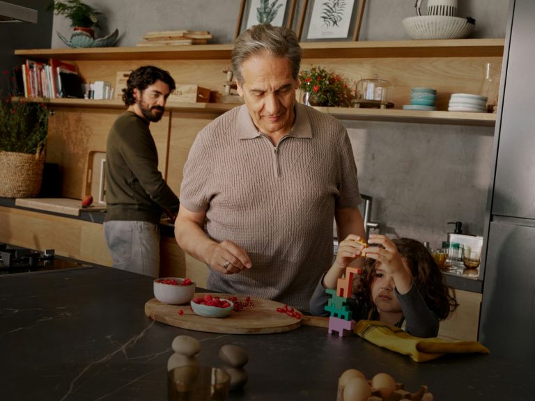 Three generations cooking together in a kitchen